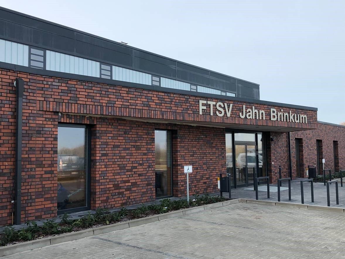 Fassade des FTSV Jahn Brinkum mit roten Ziegeln, Eingangsbereich und modernen Fenstern.
